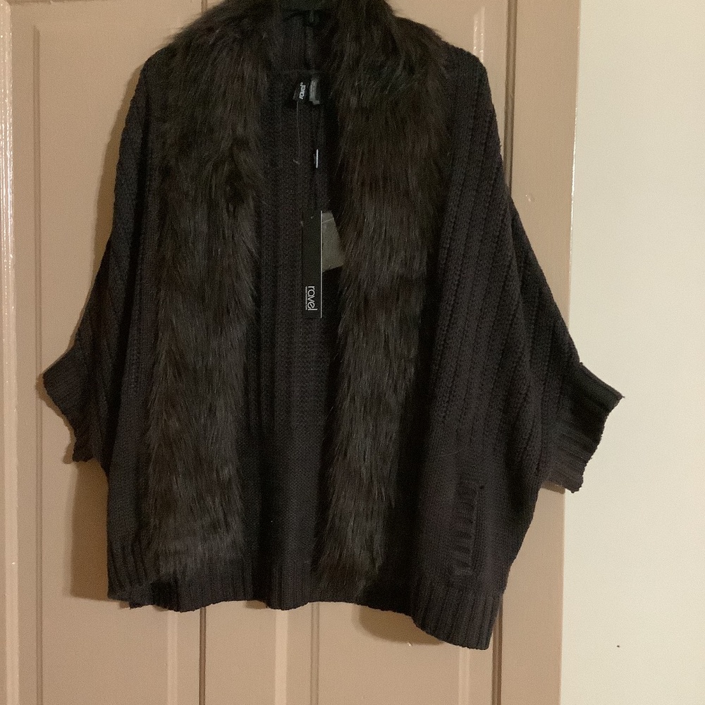 Cable stitch cape type sweater with detachable fur collar.